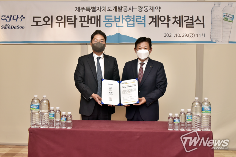 제주삼다수 유통 계약식에서 최성원 광동제약 대표이사(좌)와 김정학 제주도개발공사 사장이 기념촬영을 하고 있다. (사진=광동제약 제공)