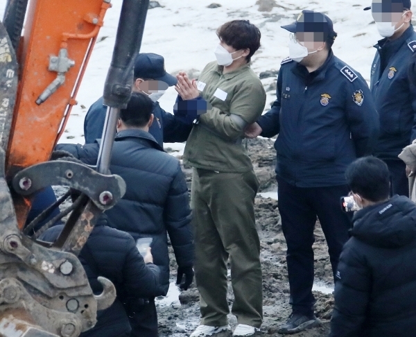 택시 기사와 동거녀를 살해한 혐의로 구속된 이기영이 6일 오후 경기도 파주 공릉천변에서 검찰 관계자들과 현장검증을 하고 있다. (사진=연합뉴스)