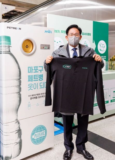 박강수 마포구청장이 마포구청 1층에 마련된 투명페트병 업사이클 체험공간에서 투명페트병 15병을 이용해 제작한 의류를 살펴보고 있다.