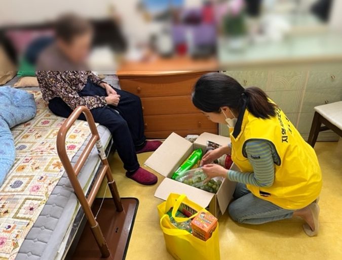 식료품꾸러미와 학습꾸러미를 전달하며 대상자의 안부를 확인하고 있는 김포시 하성면 간호직 공무원의 모습