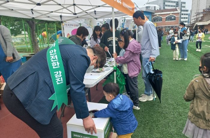 어린이 안전 캠페인으로 야광키링과 간식을 배부하고 있는 장면