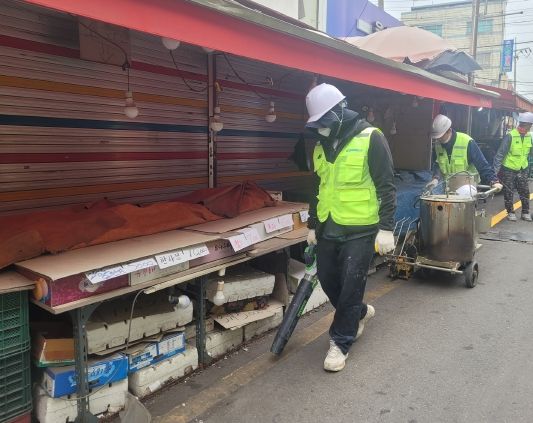 남구로시장 점포 앞 고객선에 도색작업을 하고 있다.