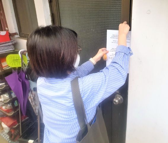 동 주민센터 직원이 부재중인 가구에 면담조사 협조 안내문을 부착하고 있다