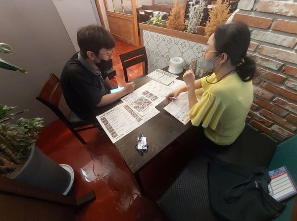 구 직원이 관내 음식점을 방문해 원산지 표시 점검을 하고 있다