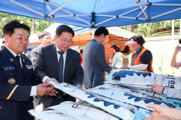 11일 열린 마포의용소방대 나눔 바자회에 박강수 구청장(중앙)이 참석해 판매 물품들을 구경하고 있다.