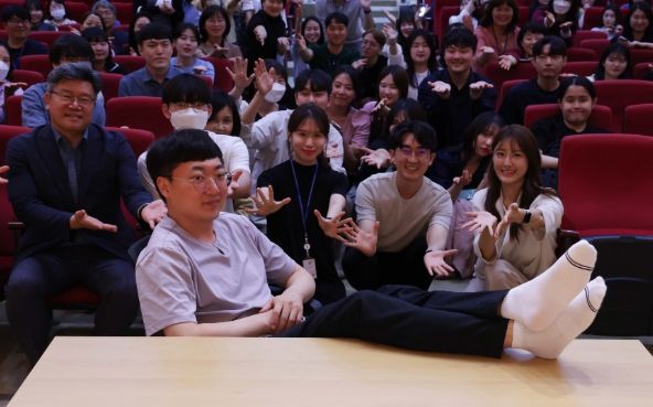 ‘충주시 홍보맨’ 김선태 주무관이 동구청 직원들에게 둘러싸여 시그니처 포즈를 취하고 있다.