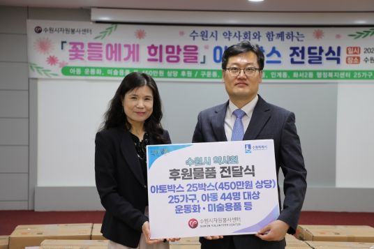 최영화(왼쪽) 수원시자원봉사센터장과 김호진 수원시약사회장이 24일 센터 4층에서 후원물품 전달식을 마친 뒤 기념 촬영을 하고 있다.