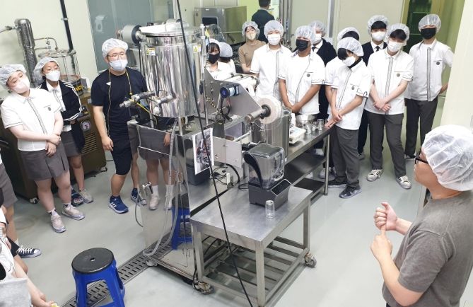 용인바이오고등학교 바이오식품과 학생들이 농산물종합가공지원센터 내 시설을 둘러보고 가공 장비에 대한 설명을 듣고 있다.