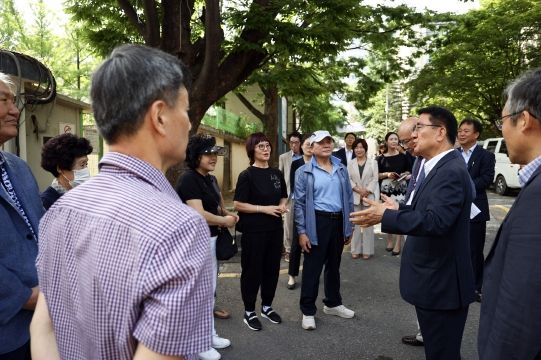 문헌일 구로구청장이 재개발․재건축사업 지원단 성과보고회 현장에서 주민들과 대화하고 있다.