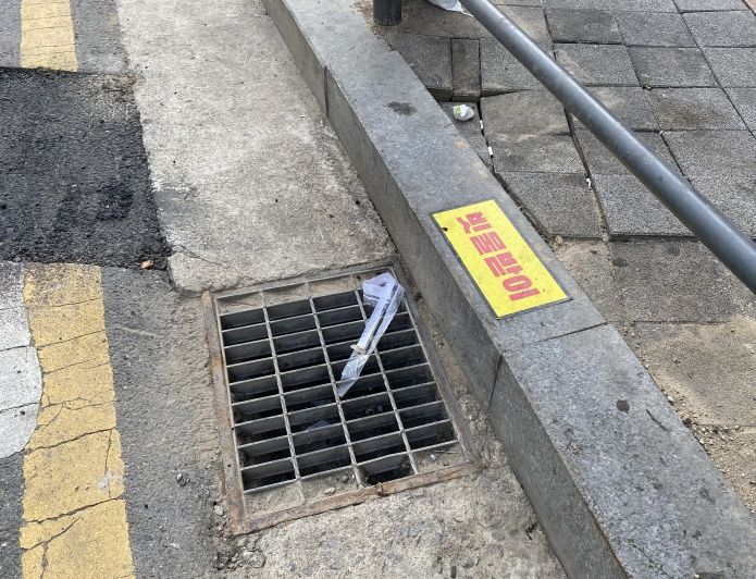 침수가 우려되는 용인특례시 기흥구 신갈동의 저지대 빗물받이 경계석 상단부에 스티커가 부착돼 있다