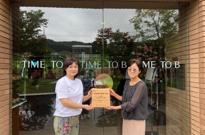 성복동 지역사회보장협의체가 타임투비에 현판을 전달했다