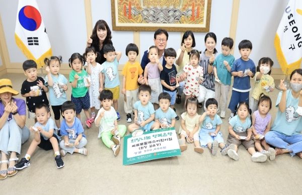 대구 수성구 메트로팔레스어린이집 교사와 아이들이 지난 10일 아나바다 바자회로 얻은 수익금 50만 원을 수성구청에 전달한 후 기념 촬영을 하고 있다.
