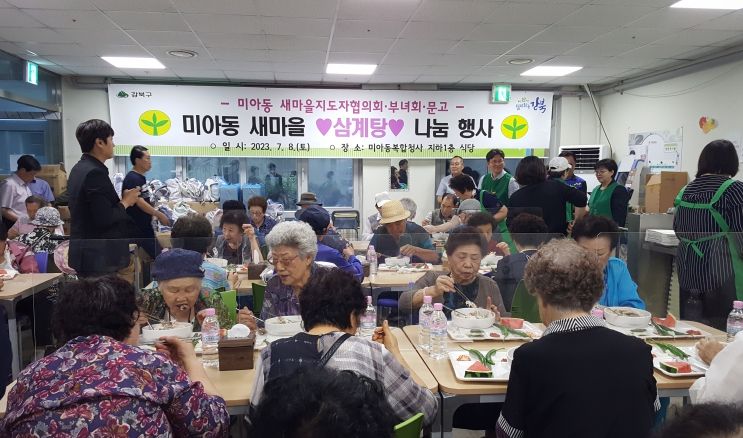 이순희 강북구청장(오른쪽에서 두번째)이 미아동 새마을단체가 주최한 ‘초복맞이 삼계탕 나눔행사’에서 어르신들의 식사를 돕고 있다.